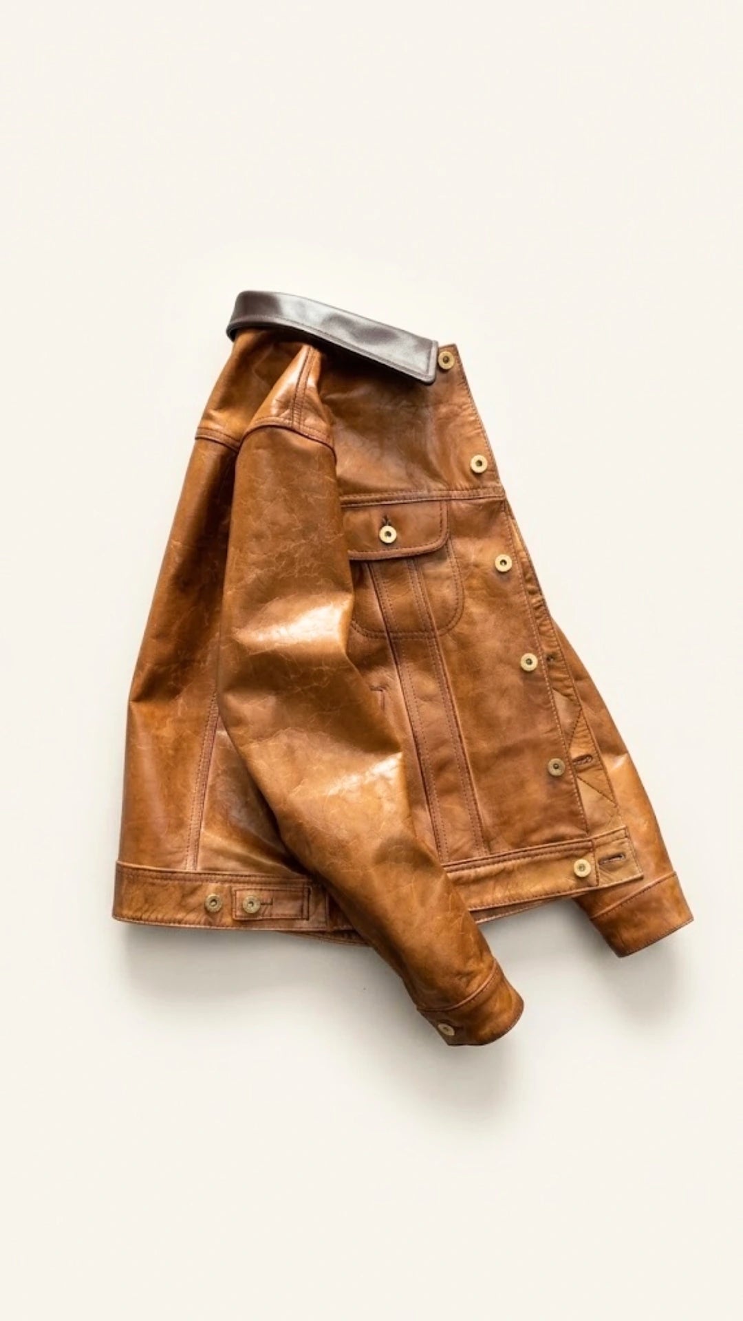 Tan goatskin jacket laid flat with one sleeve extended