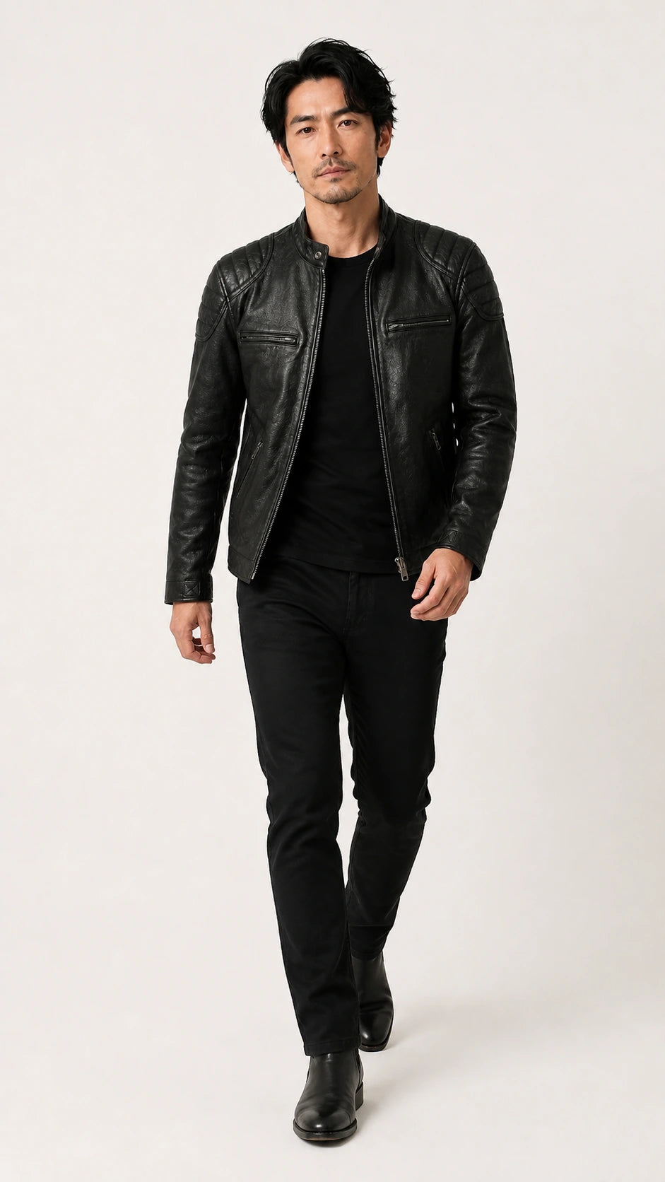 Full-length shot of a man wearing the black biker jacket with black trousers