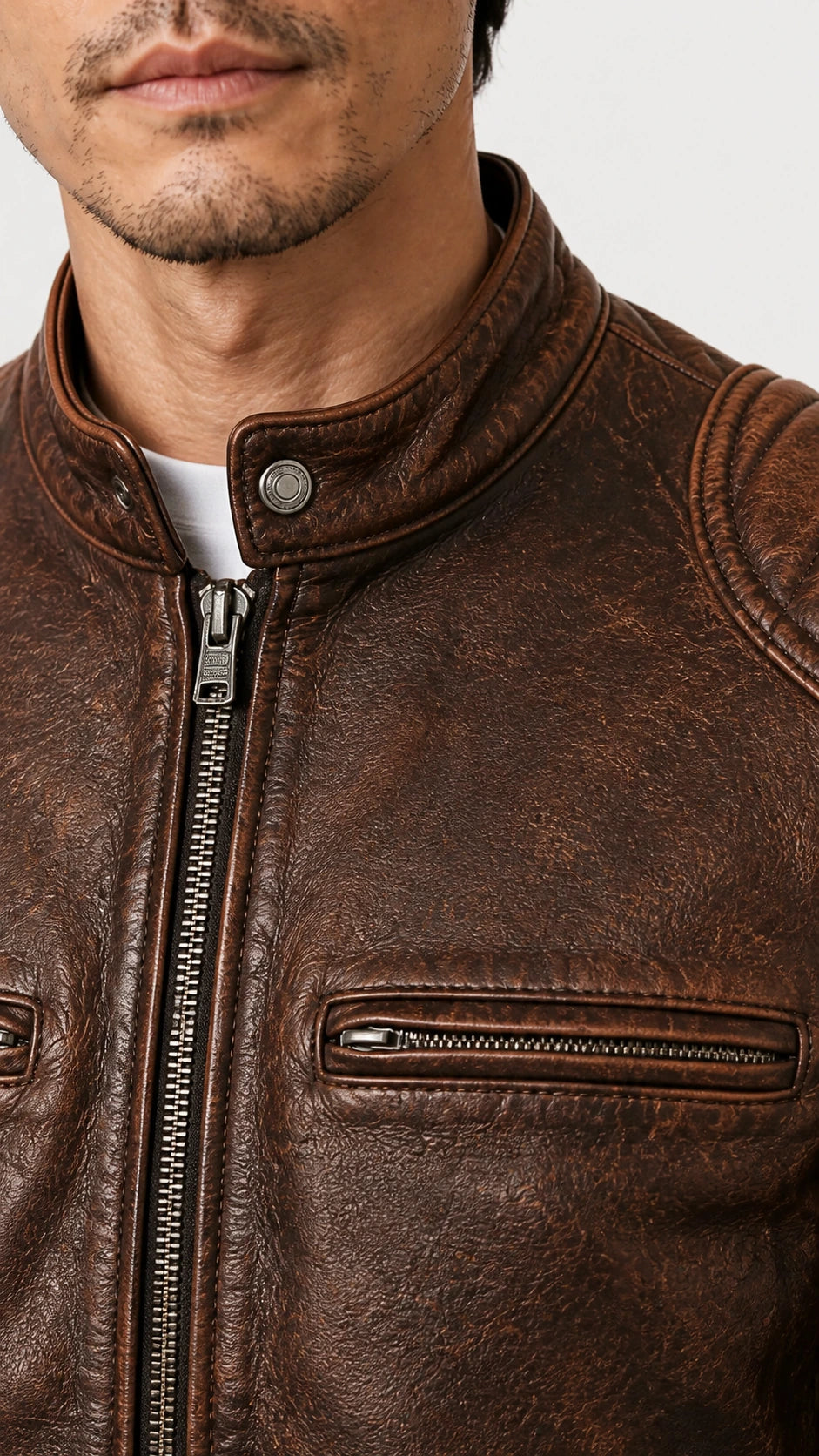 Close-up of the stand collar and zip chest pocket in distressed brown leather